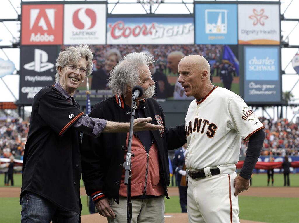 FILE - In this Oct. 14, 2014, file photo, from left to right Grateful Dead's Phil Lesh, and Bob Weir with San Francisco Giants' Tim Flannery sing the national anthem before Game 3 of the National League baseball championship series between the San Francisco Giants and the St. Louis Cardinals in San Francisco. The Giants have lost their third base coach in addition to their third baseman. On the day Pablo Sandoval finalized his reached agreement with the Boston Red Sox, third base coach Tim Flannery announced he is retiring from the Giants. (AP Photo/David J. Phillip, File)