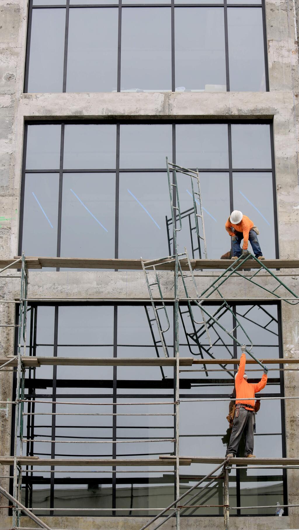 Scaffolding comes down on the Museum on the Square at the old AT&T building on Third Street in Santa Rosa, Tuesday May 19, revealing a new facade and windows. (Kent Porter / Press Democrat) 2015