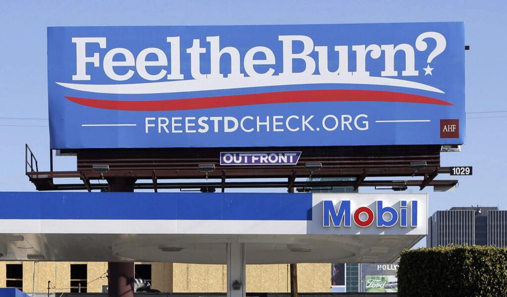 FILE - This April 1, 2016, file photo shows a billboard above a gas station that reads 'Feel The Burn,' promoting testing for sexually transmitted diseases. A state report finds the number of cases of three major sexually transmitted diseases in California reached a 30-year high in 2018. (AP Photo/Nick Ut, File)