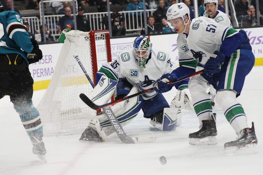 Vancouver Canucks goaltender Thatcher Demko (35) eyes the puck as his team plays the San Jose Sharks during the first period of an NHL hockey game Saturday, Nov. 2, 2019, in San Jose, Calif. (AP Photo/Jim Gensheimer)