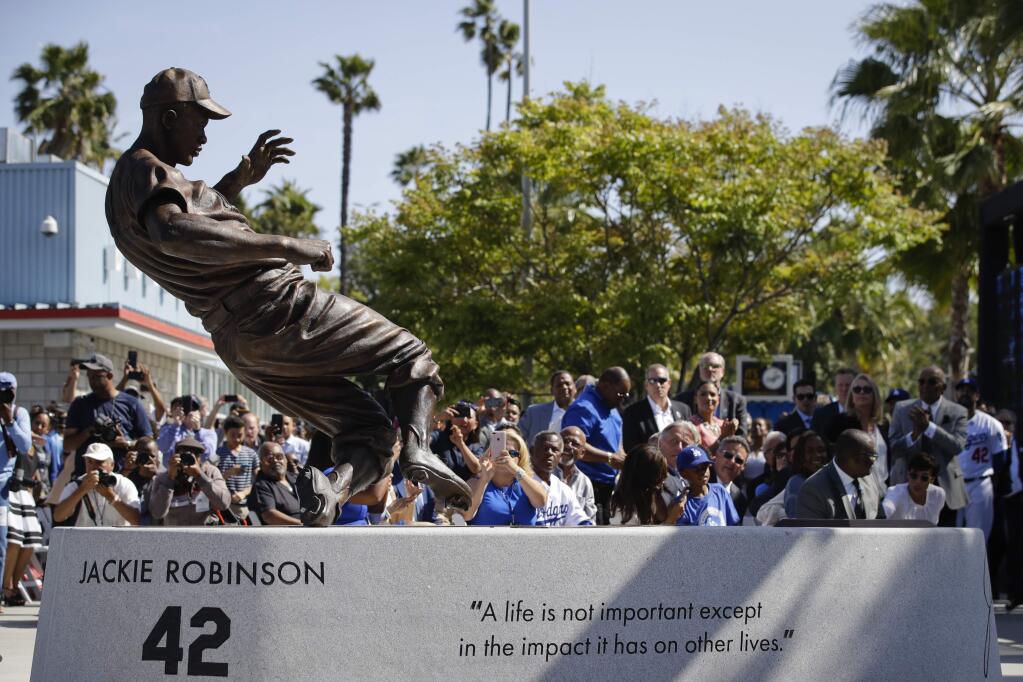 A bronze statue of Los Angeles Dodgers legend Jackie Robinson is unveiled outside Dodger Stadium before the team's game with the Arizona Diamondbacks, Saturday, April 15, 2017, in Los Angeles. (AP Photo/Jae C. Hong)