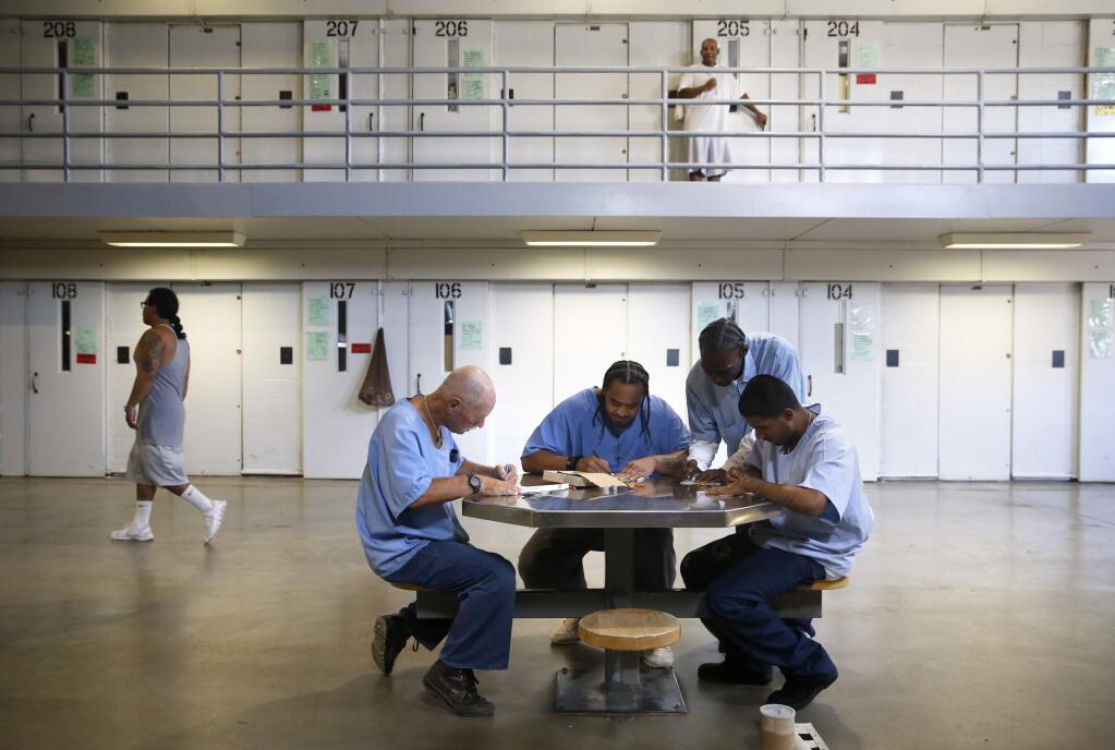 (From left) Inmates Gary Adams, Poyer Vaenuku, Ray Jackson, and Anthony Valles, part of the Artists Serving Humanity group, decorate paper luminary bags to be used for the Sonoma Relay for Life. Photo taken at California State Prison, Solano on Thursday, August 4, 2016 in Vacaville, California . (BETH SCHLANKER/ The Press Democrat)