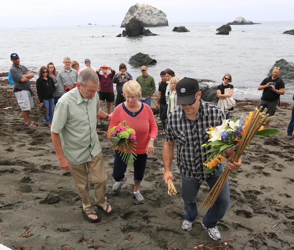 Chris and Cathy Cutshall join Sonoma County Sheriff's Sgt. Dave Thompson, Friday Aug. 15, 2014, as they place flowers for Cutshall's daughter Lindsay Cutshall and her fiance Jason Allen on Fish Head Beach just north of Jenner. (Kent Porter / Press Democrat)