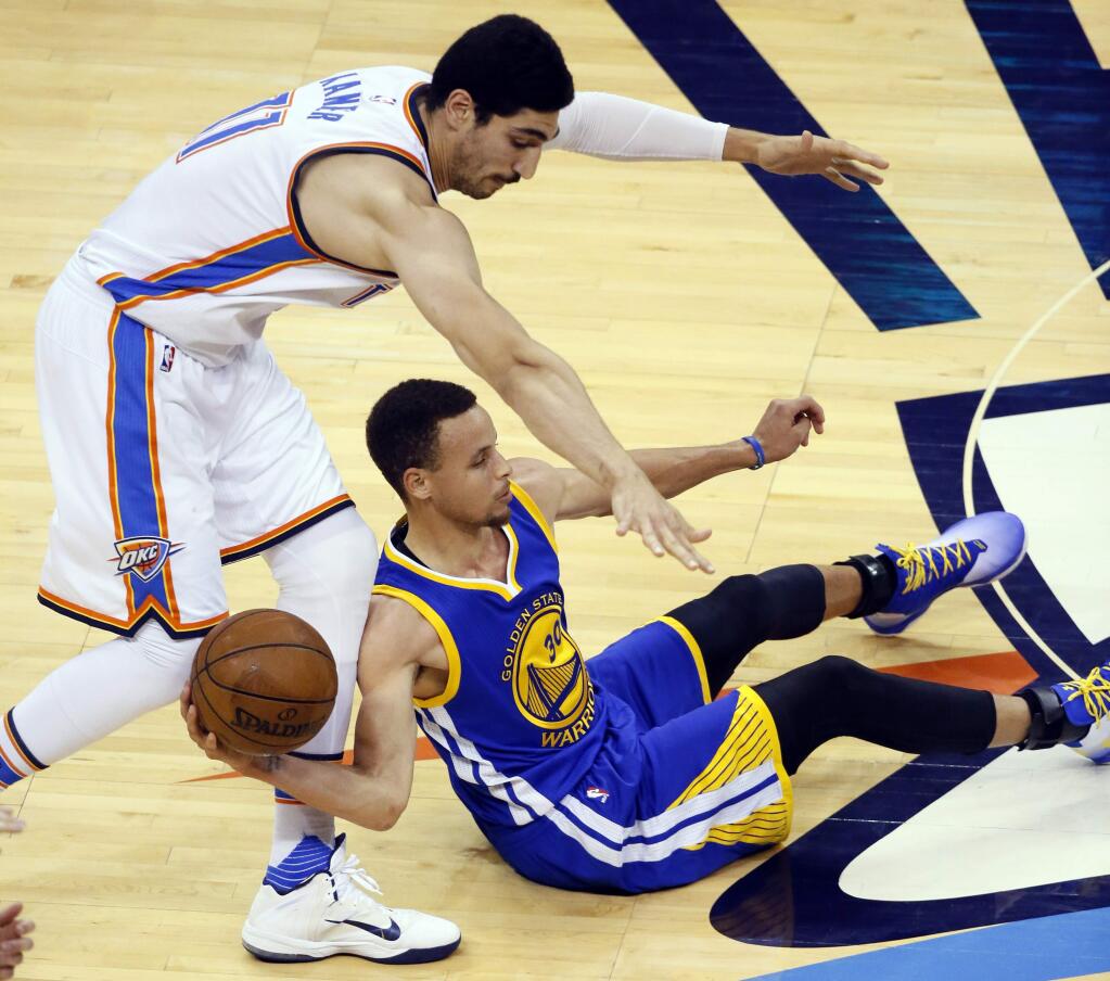 Golden State Warriors guard Stephen Curry (30) tries to pass a loose ball as Oklahoma City Thunder center Enes Kanter (11) defends in Game 4 of the NBA basketball Western Conference finals in Oklahoma City, Tuesday, May 24, 2016. (AP Photo/Sue Ogrocki)