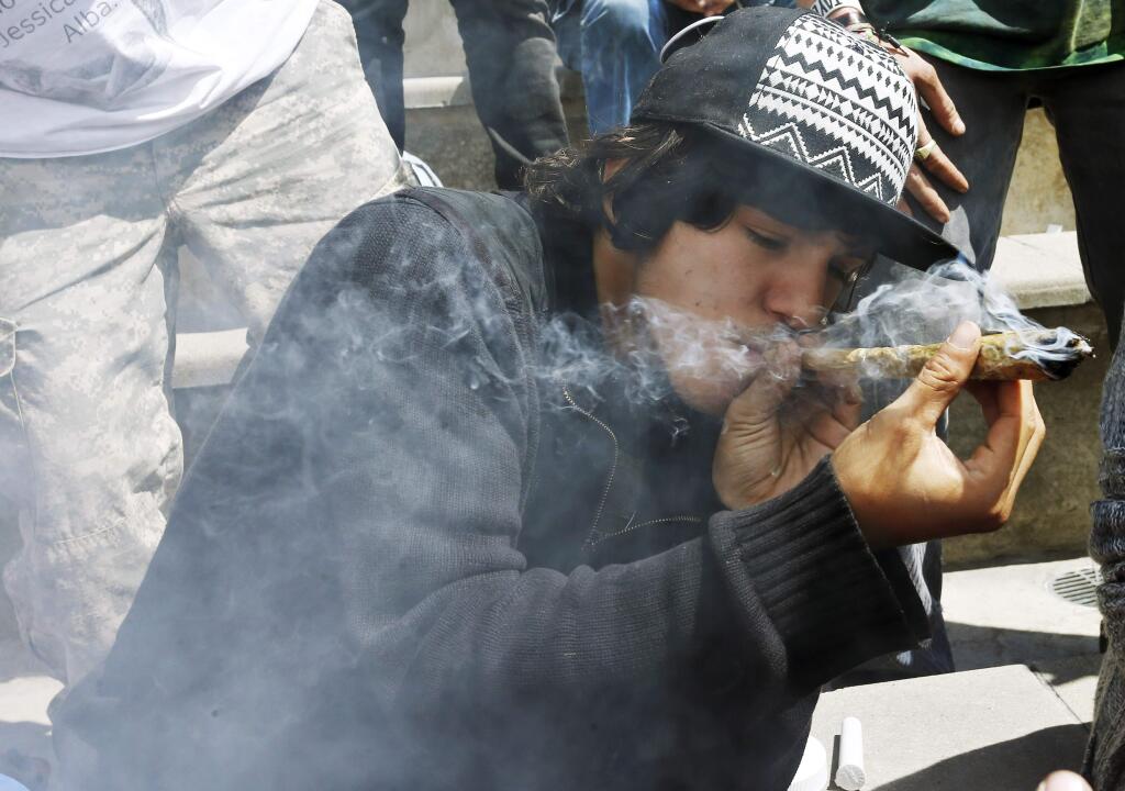 Partygoers listen to music and smoke marijuana on one of several days of the annual 4/20 marijuana festival, in Denver's downtown Civic Center Park, Saturday April 18, 2015. The annual event is the second 4/20 marijuana celebration since retail marijuana stores began selling in January 2014. (AP Photo/Brennan Linsley)