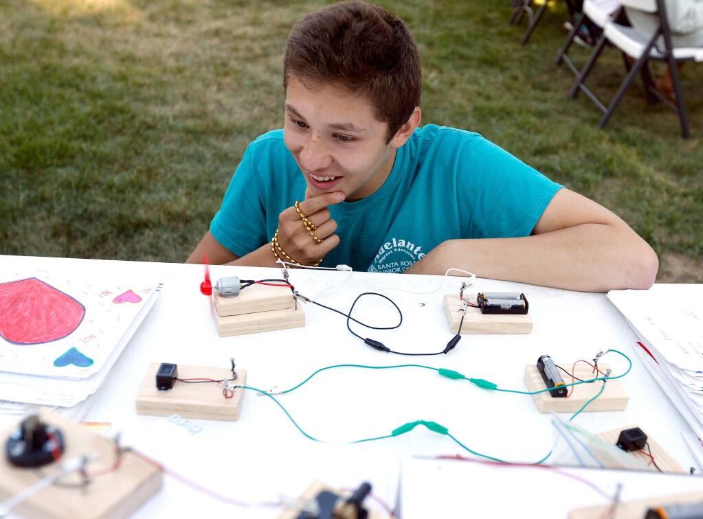 Alejandro Cardenas, 16, who is in his third summer participating in the Adelante program, ponders how to connect a series of battery-powered electric motors during parents night for students of the Adelante Migrant Education summer program at Santa Rosa Junior College in Santa Rosa, California, on Wednesday, July 18, 2018. (Alvin Jornada / The Press Democrat)