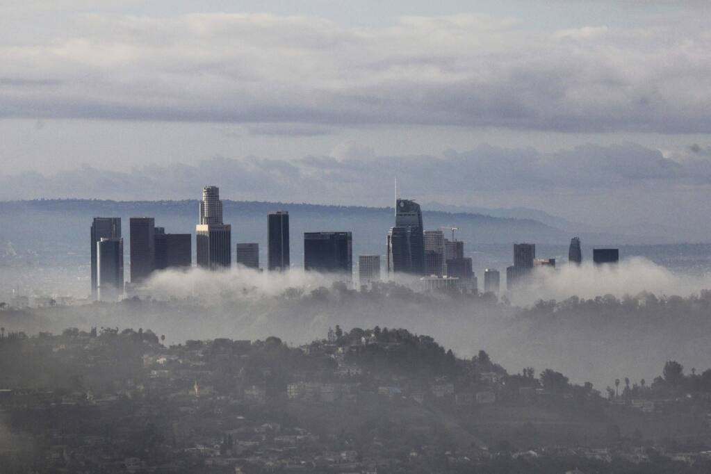 High-rises of downtown Los Angeles rise above clouds and mist on Sunday, Jan. 6, 2019, after an overnight storm that brought rain and mountain snow to Southern California. Rains unleashed debris flows from wildfire-scarred areas of the Santa Monica Mountains that inundated parts of Pacific Coast Highway. (AP Photo/John Antczak)