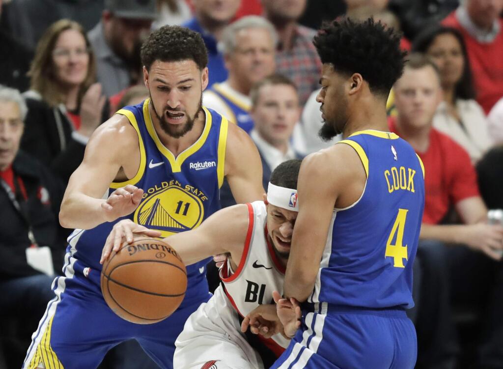 Golden State Warriors guards Klay Thompson, left, and Quinn Cook, right, close in on Portland Trail Blazers guard Seth Curry, center, during the first half of Game 4 of the NBA basketball playoffs Western Conference finals, Monday, May 20, 2019, in Portland, Ore. (AP Photo/Ted S. Warren)