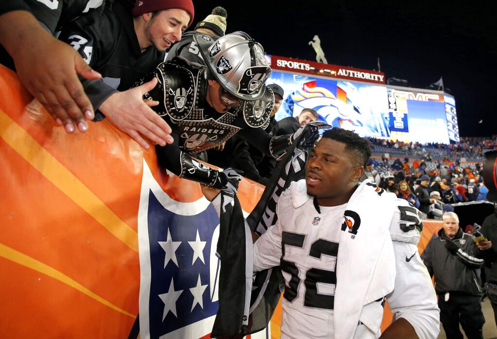 Oakland Raiders defensive end Khalil Mack (52) greets Raiders fans after an NFL football game against the Denver Broncos, Sunday, Dec. 13, 2015, in Denver. The Raiders won 15-12. (AP Photo/Jack Dempsey)