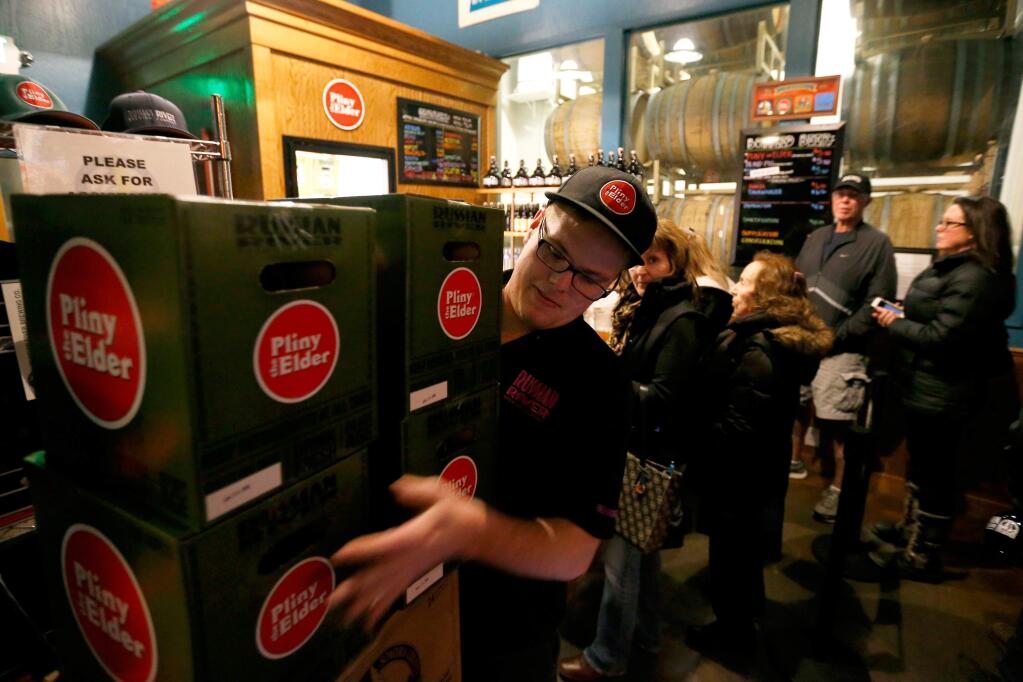 Gift shop attendant Trent Williams stacks cases of beer for a customer's purchase at Russian River Brewing Company in Santa Rosa, California, on Thursday, February 4, 2016. Russian River Brewing Company will release their popular triple IPA, Pliny the Younger, starting tomorrow for a limited time. (Alvin Jornada / The Press Democrat)