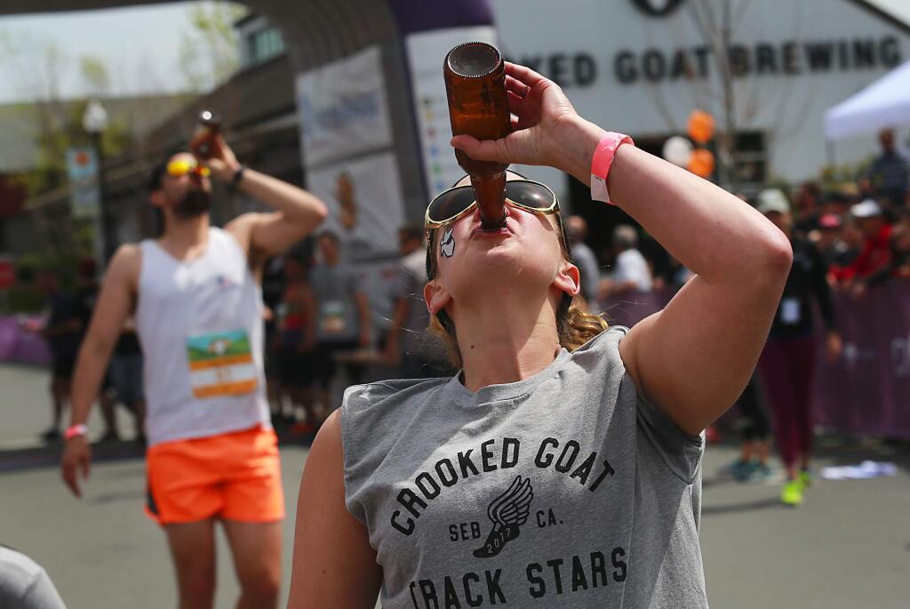 Competitors in the 2017 Beer Mile Invitational try to outrun and outdrink each other as they chugged a beer every quarter mile before dashing around The Barlow in Sebastopol. (John Burgess / The Press Democrat)