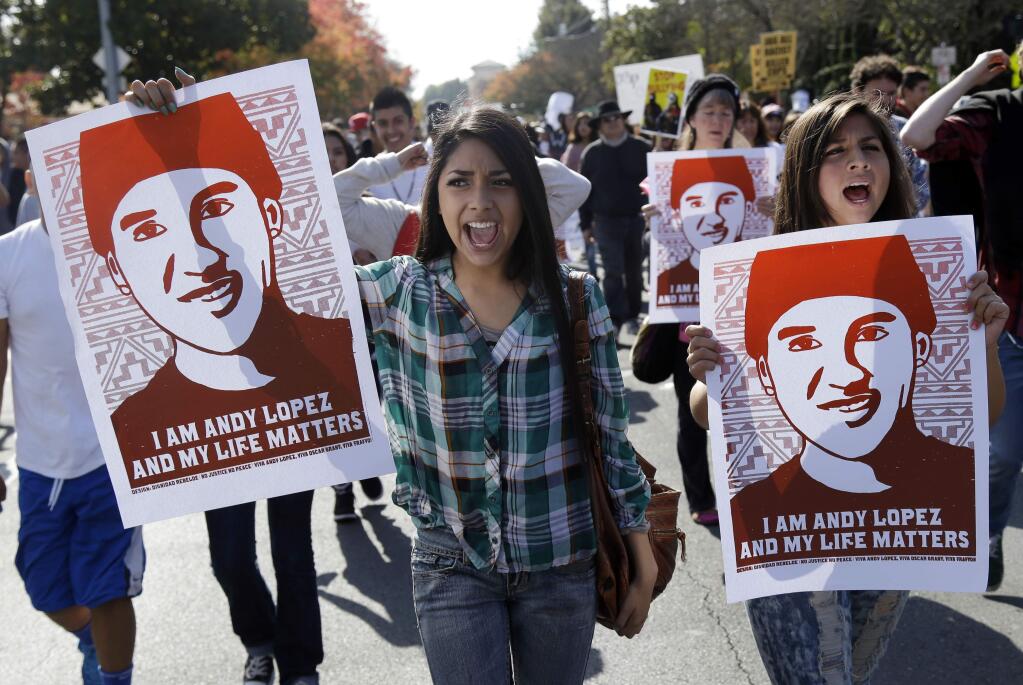Protesters carrying images of Andy Lopez march through Santa Rosa in March. He was shot and killed by a deputy sheriff who mistook his airsoft BB gun for an authentic firearm. (MARCIO JOSE LOPEZ / Associated Press)