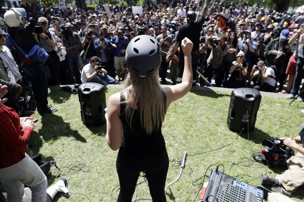 Lauren Southern wears a protective helmet as she speaks during a rally for free speech Thursday, April 27, 2017, in Berkeley, Calif. Demonstrators gathered near the University of California, Berkeley campus amid a strong police presence and rallied to show support for free speech and condemn the views of Ann Coulter and her supporters. (AP Photo/Marcio Jose Sanchez)