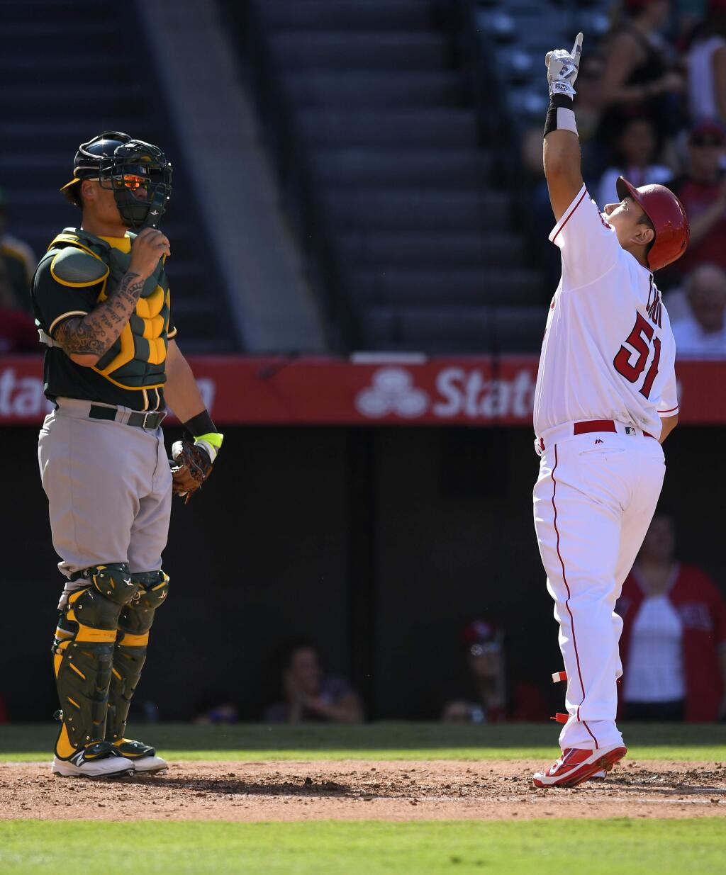 Los Angeles Angels' Ji-Man Choi, right, points to the sky after hitting a solo home run, as Oakland Athletics catcher Bruce Maxwell watches during the second inning of a baseball game Thursday, Aug. 4, 2016, in Anaheim, Calif. (AP Photo/Mark J. Terrill)