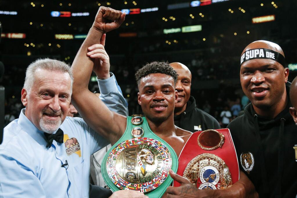 FILE - IN this Sept. 28, 2019, file photo, Errol Spence Jr., center, celebrates his victory over Shawn Porter during the WBC & IBF World Welterweight Championship boxing match in Los Angeles. Authorities say welterweight boxing champion Spence was seriously injured but is expected to survive after crashing his Ferrari in Dallas. Dallas police say the crash happened just before 3 a.m. Thursday, Oct. 10, 2019, when Spence's Ferrari crossed the median into oncoming traffic and flipped over several times. (AP Photo/Ringo H.W. Chiu, File)