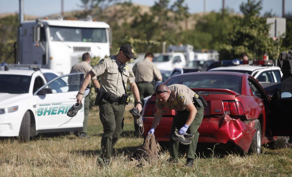 Members of the Sonoma County Sheriff's Office investigate the end scene of a high speed chase at the corner of Stony Point Road and Petaluma Blvd North on Wednesday, May 22, 2013 in Petaluma, California. (BETH SCHLANKER/ The Press Democrat)