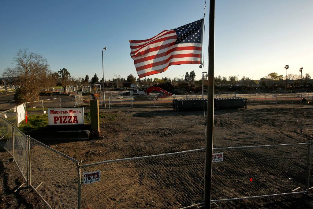 An American flag flies at half staff above the cleared property that was the location of Mountain Mike's Pizza, with what remains of K-mart in the background, on Cleveland Avenue in Santa Rosa, California, on Wednesday, February 21, 2018. Both businesses were destroyed during the Tubbs fire in October 2017. (Alvin Jornada / The Press Democrat)