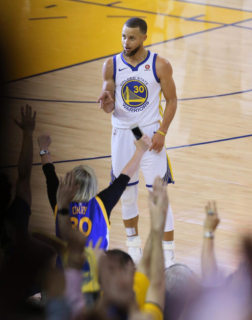 Golden State Warriors guard Stephen Curry celebrates a three-pointer to beat the halftime buzzer against the Cleveland Cavaliers, during Game 1 of the NBA Finals in Oakland on Thursday, May 31, 2018. (Christopher Chung/ The Press Democrat)