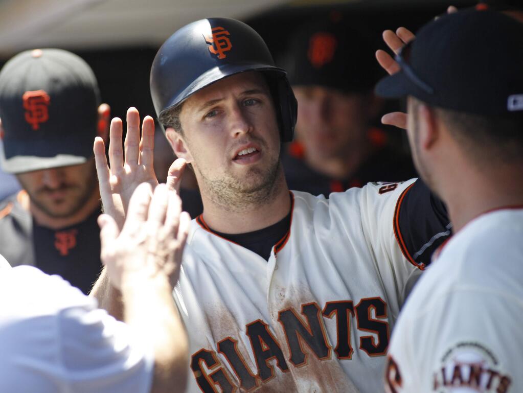 San Francisco Giants' Buster Posey is greeted in the dugout after scoring against the Philadelphia Phillies during the third inning of a baseball game, Sunday, June 26, 2016, in San Francisco. (AP Photo/George Nikitin)