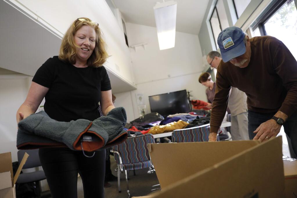 Volunteers Denise Rose, left, and Bob Crozier box up coats to be sent to Chico, Ca. at the Jewish Community Center, Sonoma County in Santa Rosa on Thursday, December 6, 2018. (BETH SCHLANKER/ The Press Democrat)