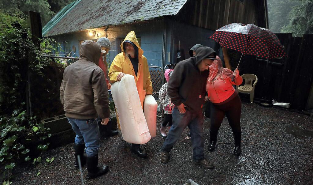 Tony Harley, middle, helps a friend evacuate belongings Tuesday, Feb. 26, 2019 in Rio Nido, as the Russian river nears flood stage. (Kent Porter / The Press Democrat) 2019