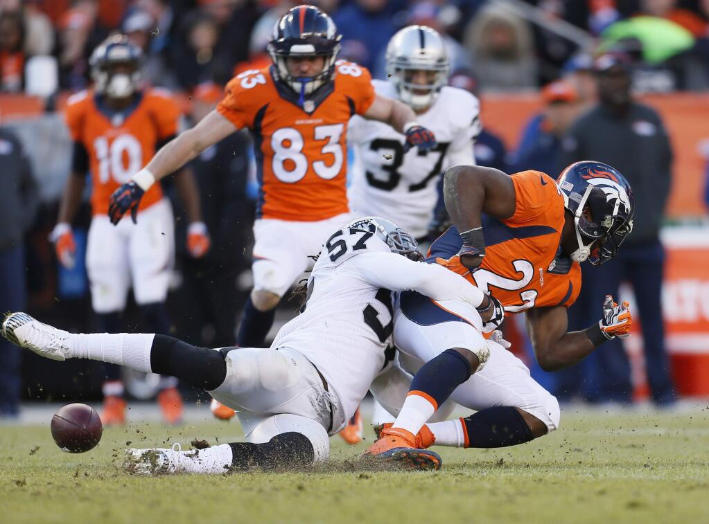 Oakland Raiders outside linebacker Ray-Ray Armstrong (57) forces Denver Broncos running back C.J. Anderson (22) to fumble during the first half of an NFL football game, Sunday, Dec. 28, 2014, in Denver. The Broncos recovered the ball. (AP Photo/Joe Mahoney)