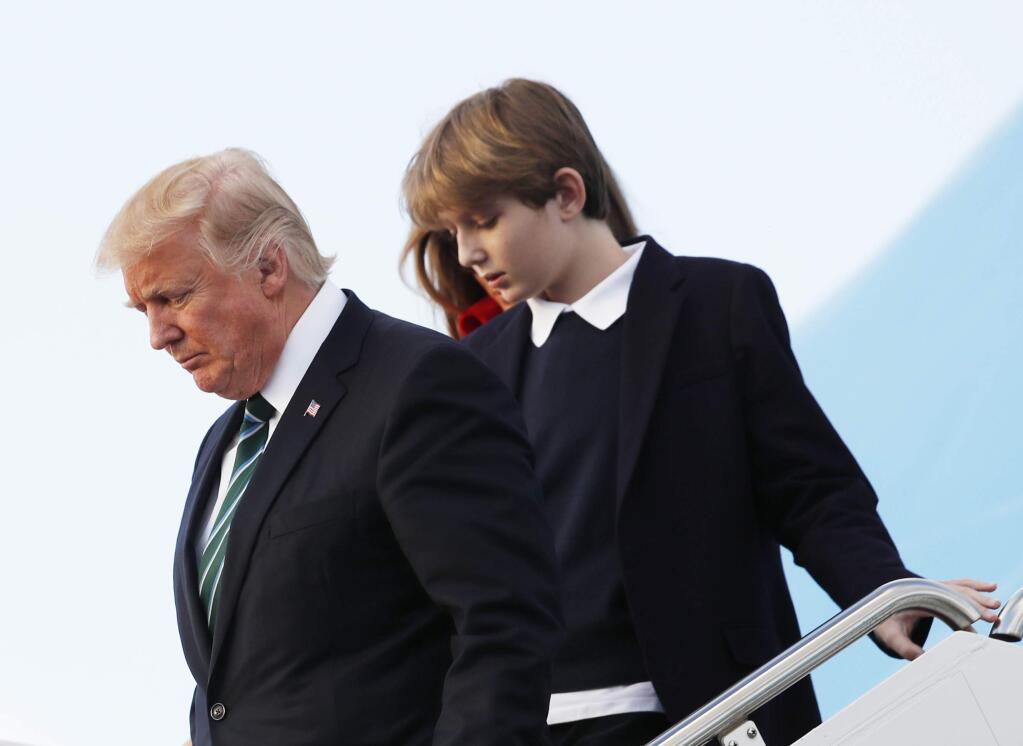 In this photo taken March 17, 2017, Barron Trump, with his father President Donald Trump and mother, first lady Melania Trump, disembark from Air Force One upon arrival at Palm Beach International Airport in West Palm Beach, Fla. First lady Melania Trump has announced that her son, Barron, will attend a private Episcopal school in Maryland beginning this fall. (AP Photo/Manuel Balce Ceneta)