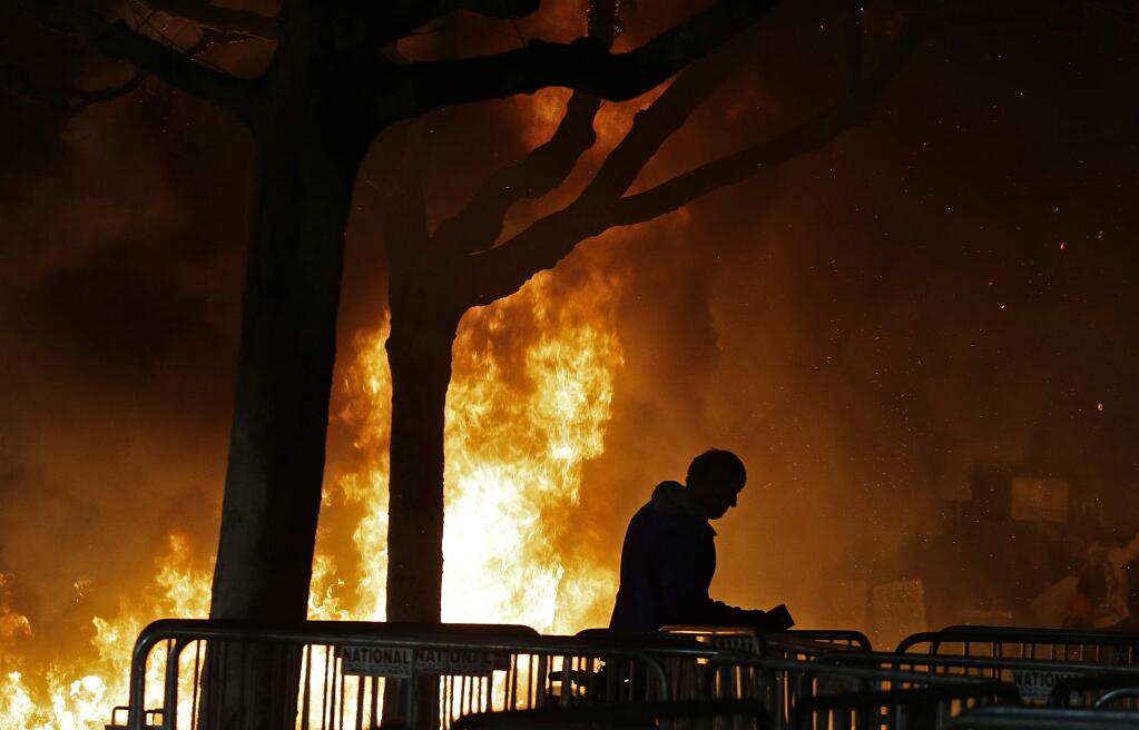 FILE - In this Wednesday, Feb. 1, 2017, file photo, a bonfire set by demonstrators protesting a scheduled speaking appearance by Breitbart News editor Milo Yiannopoulos, burns on Sproul Plaza on the University of California at Berkeley campus on in Berkeley, Calif. Trump supporters and left-wing protesters have taken to the streets repeatedly in recent months in supposed free-speech demonstrations accompanied by escalating violence. But even on the so-called 'Left Coast,' officials in famously liberal cities such as Portland and Berkeley are growing tired of the repeated violence. (AP Photo/Ben Margot, File)