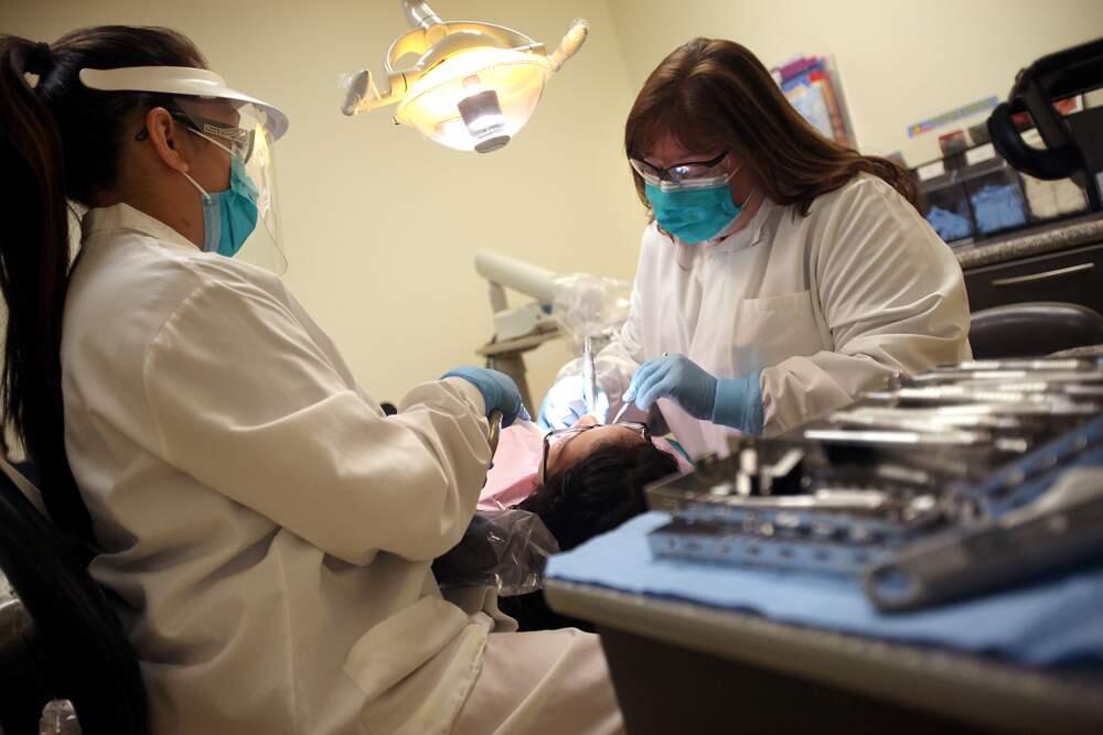 Elvira Fiorentino, D.D.S., right, and dental assistant Erika Meza work on 12-year-old Martha Martinez's teeth at Alliance Medical Center Dental Clinic in Healdsburg on Thursday, March 28, 2013. The clinic is receiving a half million dollar grant to expand their early childhood dental development program. (Christopher Chung / The Press Democrat)