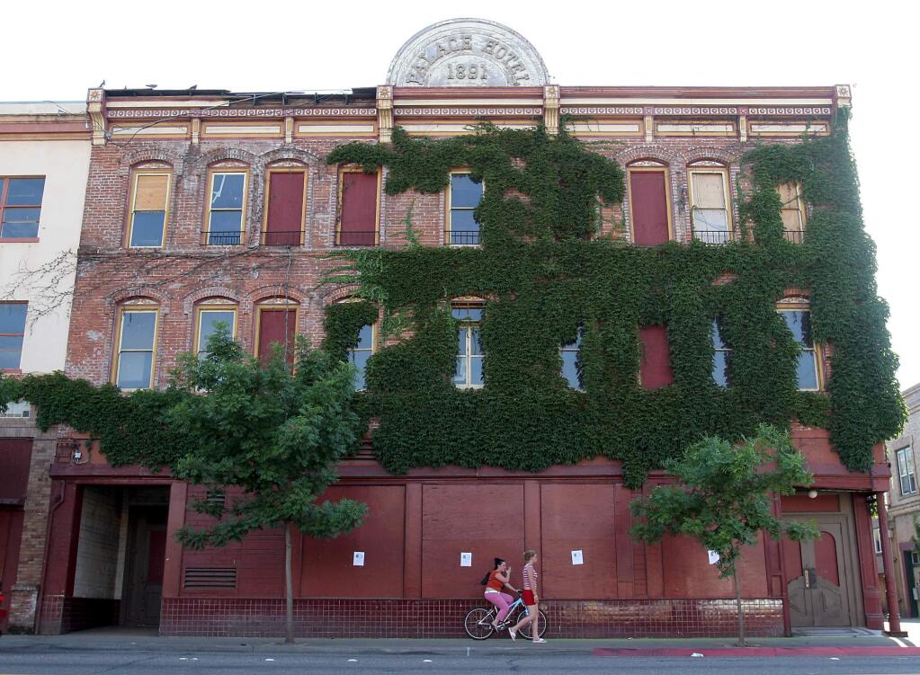 Teenagers pass in front of the boarded up Palace Hotel in downtown Ukiah in this 2005 photo. The historic hotel has been dormant and rotting for more than two decades.