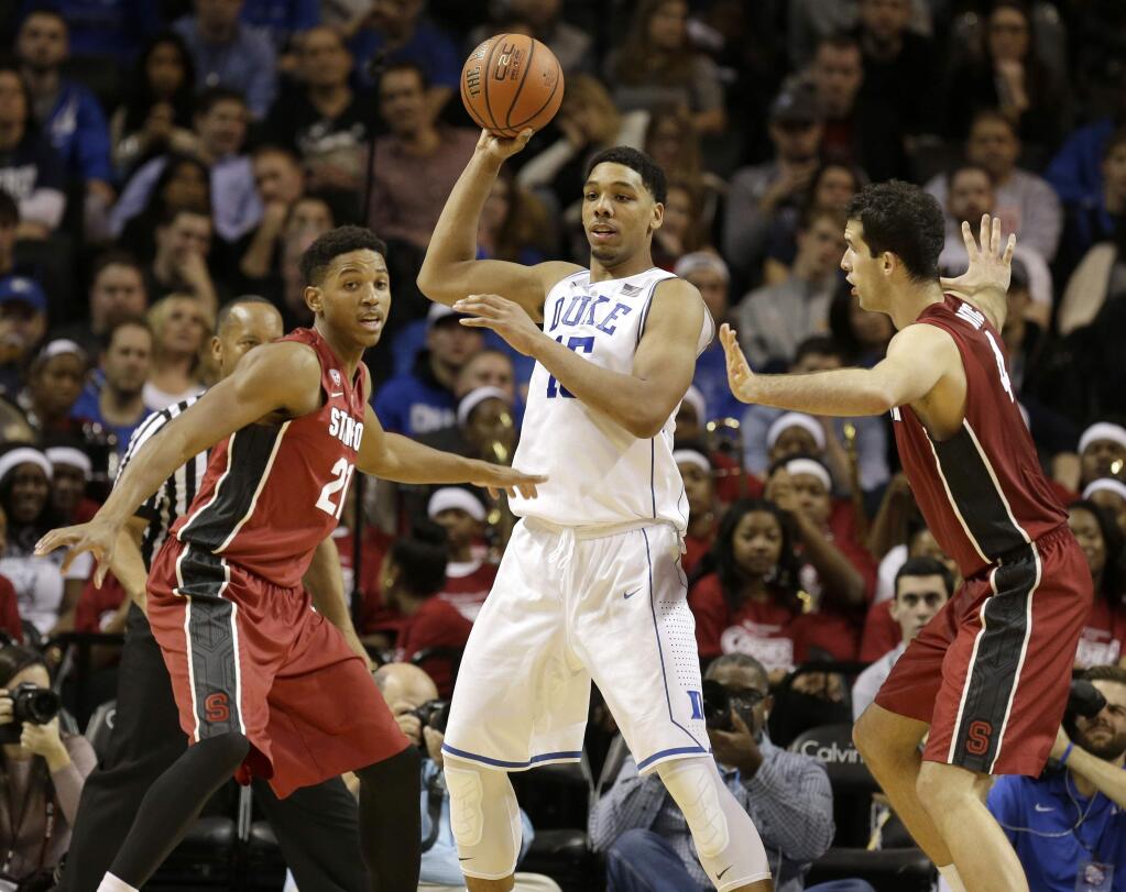 Duke's Jahlil Okafor, center, is guarded by Stanford's Anthony Brown, left, and Stefan Nastic during the first half of a game for first place in the Coaches vs. Cancer Classic, Saturday, Nov. 22, 2014, in New York. (AP Photo/Seth Weng)