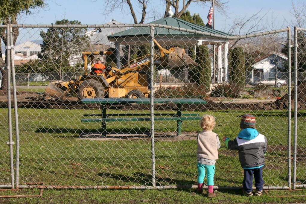 Nico Firestone, left, celebrating his 2nd birthday, and his friend Phoenix Encinas, also 2, are mesmerized by the construction as work continues on the new walkways at Walnut park on Tuesday, January 6 2015. (SCOTT MANCHESTER/ARGUS-COURIER STAFF)