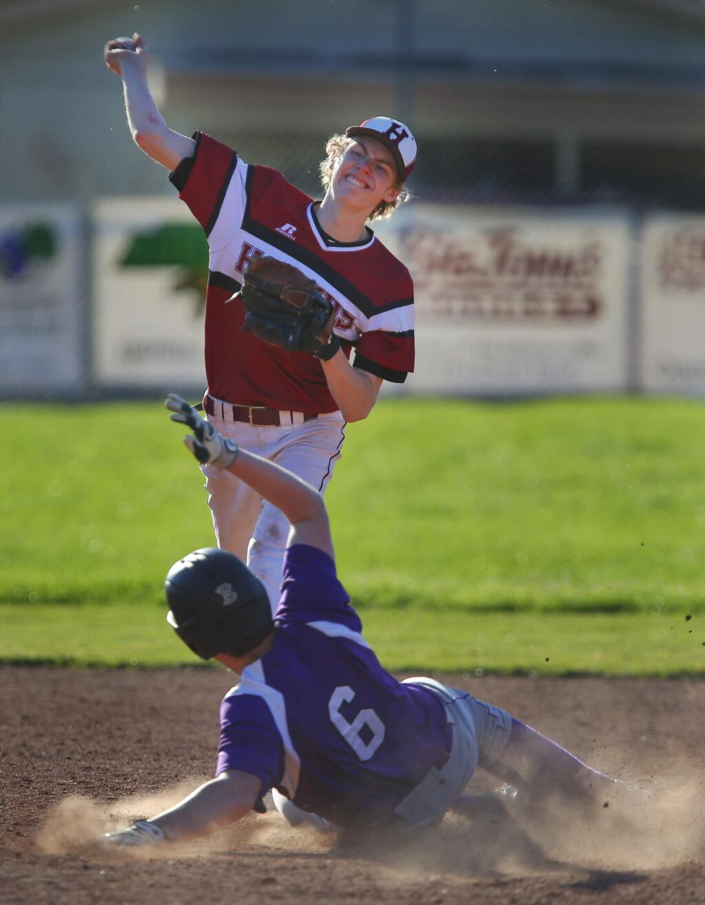 Healdsburg's Jacob Pruitt tries to turn the double play as Fort Bragg's Colton Hopper slides into second, during their preseason game in Healdsburg, on Wednesday, March 16, 2016. (Christopher Chung/ The Press Democrat)