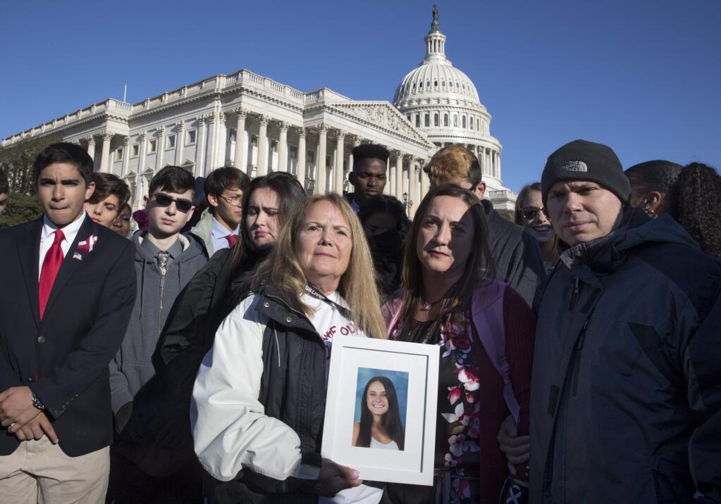 Terri Robinowitz, center, holds a framed photo of her granddaughter Alyssa Alhadeff who was killed in the shootings at Marjory Stoneman Douglas High School, with Alyssa's parents, Lori Alhadeff and Ilan Alhadeff, right, as lawmakers and gun control activists gather at the U.S. Capitol in Washington, Friday, March 23, 2018, a day before the March for Our Lives rally Saturday. (AP Photo/J. Scott Applewhite)