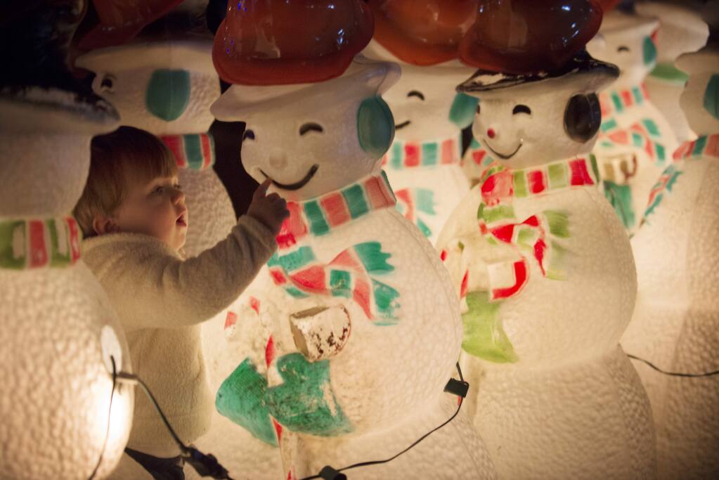 Hunter Ham, 18-months, of Sonoma, examining one of the lit snowmen during the Annual Lighting of the Snowmen Festival held Saturday at Cornerstone on Arnold Drive in Sonoma. Several hundred attendees enjoyed ice skating, hot chocolate, food trucks and walking through a field of 200 lit snowman wearing yellow hard hats to represent the rebuilding of Sonoma County after the recent fires. The festival began in 2004 when Artefact Design & Salvage owner David Allen bought hundreds of decorative snowmen from a Boston factory going out of business. Proceeds from tonight's event will go towards Redwood Credit Union North Bay Fire Relief Fund. December 2, 2017.(Photo: Erik Castro/for The Press Democrat)