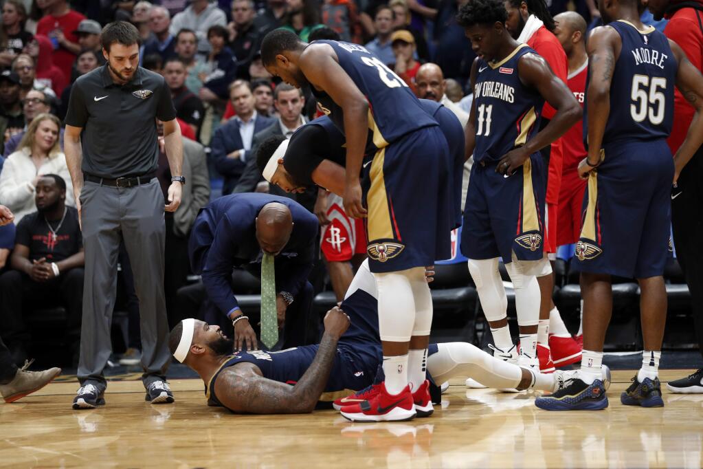 New Orleans Pelicans center DeMarcus Cousins lies on the court after injuring his left achilles tendon, according to the team, in the second half of an NBA basketball game against the Houston Rockets in New Orleans, Friday, Jan. 26, 2018. The Pelicans won 115-113. (AP Photo/Gerald Herbert)