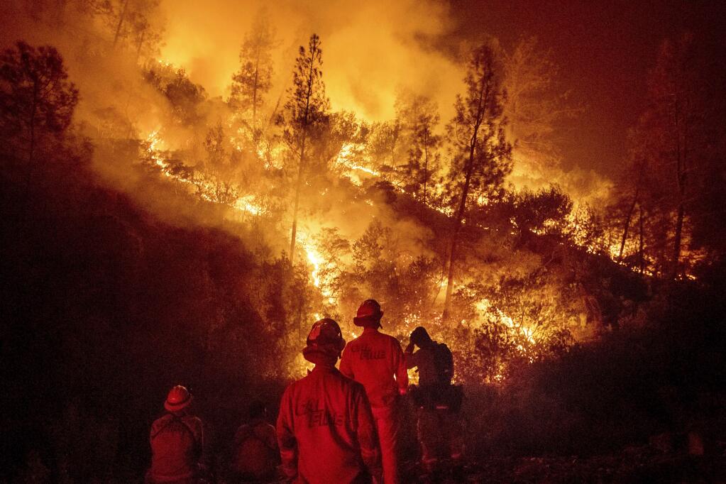 FILE - In this Aug. 7, 2018 file photo, firefighters monitor a backfire while battling the Ranch Fire, part of the Mendocino Complex Fire near Ladoga, Calif. The years with the most acres burned by wildfires have some of the hottest temperatures, an Associated Press analysis of fire and weather data found. As human-caused climate change has warmed the world over the past 35 years, the land consumed in flames has more than doubled. (AP Photo/Noah Berger)