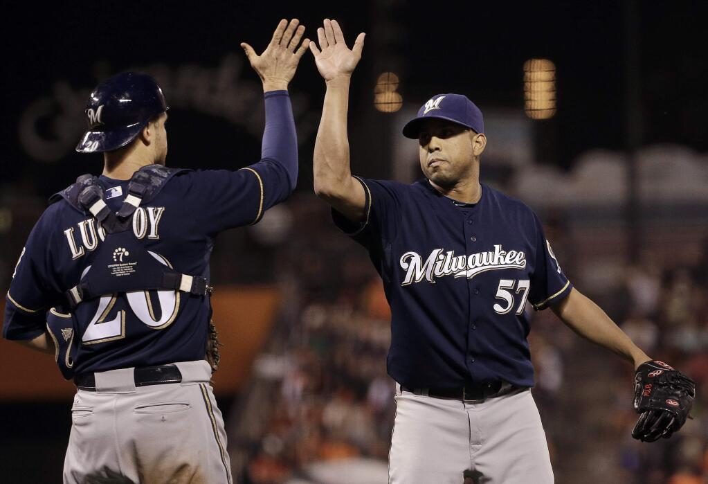 Milwaukee Brewers pitcher Francisco Rodriguez (57) and catcher Jonathan Lucroy (20) celebrate after beating the San Francisco Giants 5-2 in a baseball game in San Francisco, Tuesday, July 28, 2015. (AP Photo/Jeff Chiu)