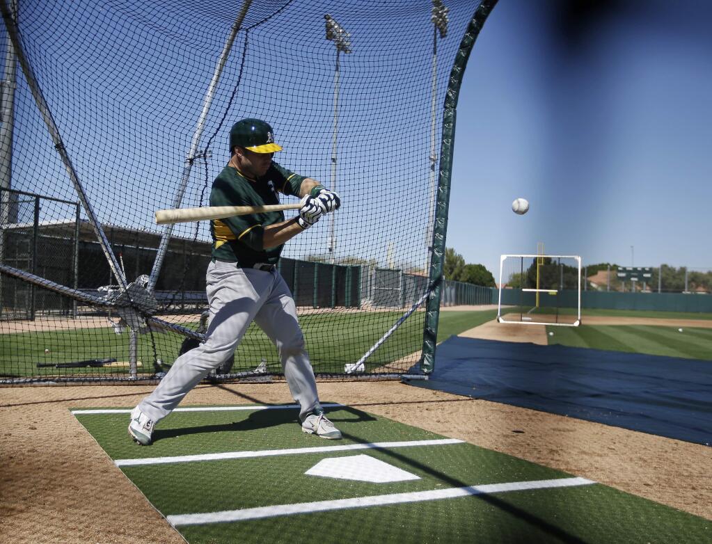 Oakland Athletics' Josh Phegley (19) hits during spring training baseball practice Wednesday, Feb. 25, 2015, in Mesa, Ariz. (AP Photo/Darron Cummings)