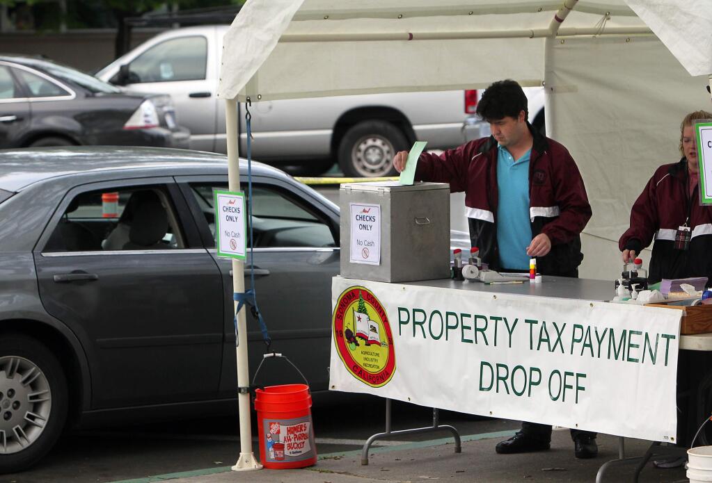 Brian Pacula places a property tax payment into a secure box at the drive-up payment booth in the Sonoma County Administration Center in Santa Rosa in 2015.