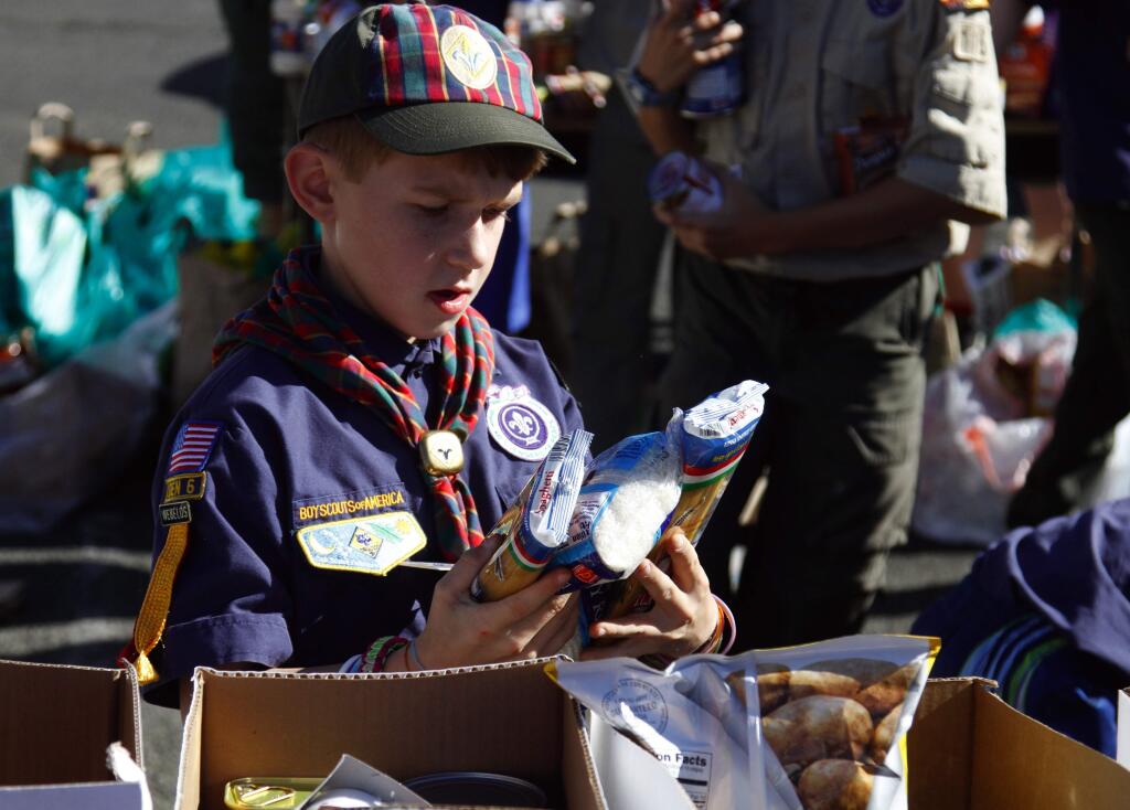 Bill Hoban/Index-TribuneSorting food for FISHTully Meyer, 10, a Cub Scout in Pack 16, was one of numerous Scouts sorting food at the Fiesta Plaza last Saturday during the annual Scouting for Food Drive. The Cub Scouts and Boy Scouts collected almost 3,500 pounds of food – enough to fill about 120 boxes. The total was about 1,000 pounds more than the Scouts collected last year. All of the food is for FISH's Christmas baskets that go to the needy.