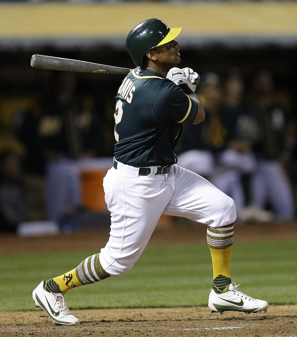 Oakland Athletics' Khris Davis watches his RBI sacrifice fly against the Texas Rangers during the sixth inning of a baseball game Tuesday, April 18, 2017, in Oakland, Calif. (AP Photo/Ben Margot)