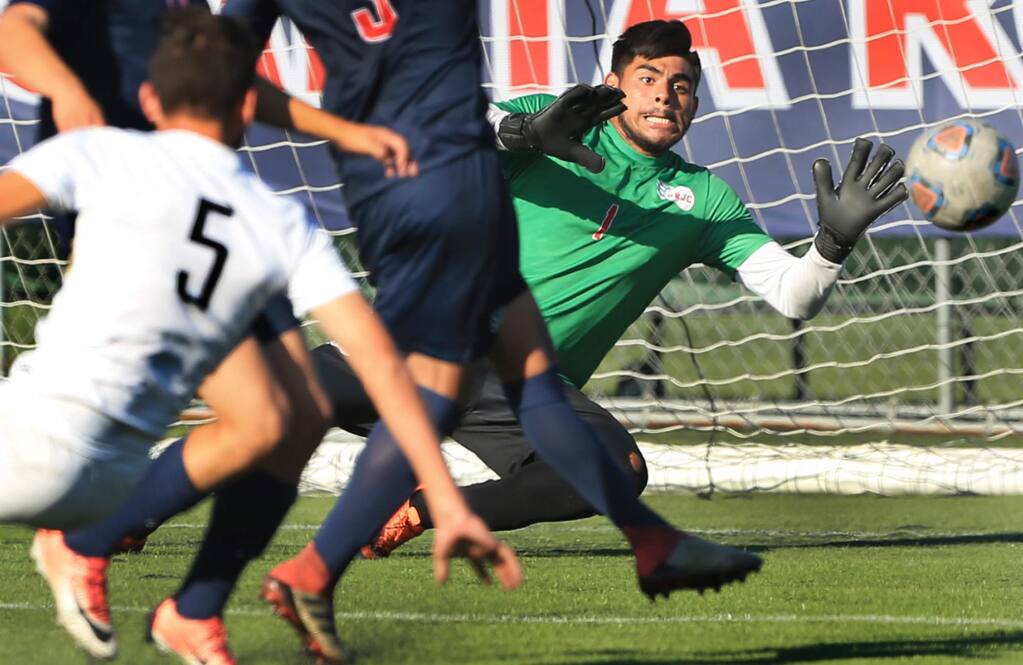 Santa Rosa goalkeeper Javier Aguilar makes a stop on goal from Miguel Millan, No. 5, of Delta College during the first-half Tuesday, Sept. 25, 2018, at Santa Rosa Junior College. (Kent Porter / Press Democrat)