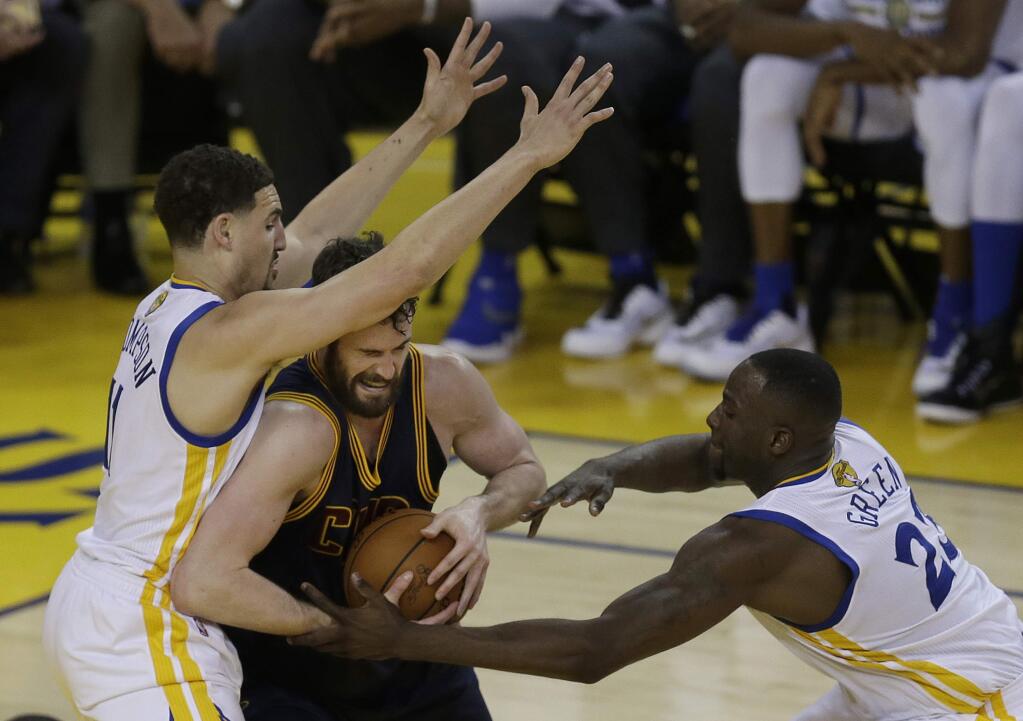 Cleveland Cavaliers forward Kevin Love, center, is defended by Golden State Warriors guard Klay Thompson, left, and forward Draymond Green (23) during the second half of Game 1 of basketballs NBA Finals in Oakland, Calif., Thursday, June 2, 2016. (AP Photo/Ben Margot)