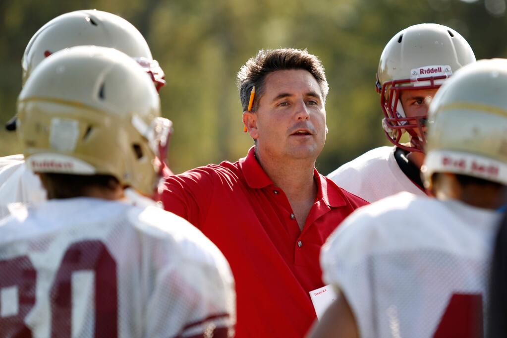 Cardinal Newman head coach Paul Cronin talks with some of his players during varsity football practice at Cardinal Newman high school in Santa Rosa, California, on August 19, 2015.