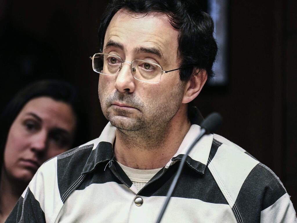 FILE - In this Feb. 17, 2017, file photo, Dr. Larry Nassar listens to testimony of a witness during a preliminary hearing, in Lansing, Mich. The longtime sports doctor at Michigan State University and USA Gymnastics has been ordered to stand trial on charges alleging he sexually assaulted six young gymnasts while they sought treatment for injuries. Judge Donald Allen Jr. made his decision Friday, June 23 in Mason, Mich., after hearing testimony from the gymnasts and watching a police interview of the doctor. (Robert Killips /Lansing State Journal via AP)