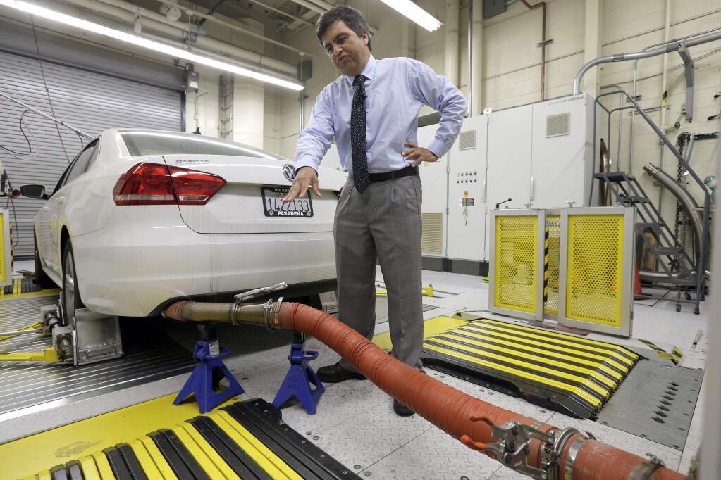 FILE - In this Sept. 30, 2015, file photo, John Swanton, spokesman with the California Air Resources Board, explains how a 2013 Volkswagen Passat with a diesel engine is evaluated at the emissions test lab in El Monte, Calif. A U.S. appeals court on Monday, July 9, 2018, approved a $10 billion settlement between Volkswagen and car owners caught up in the company's emissions cheating scandal. (AP Photo/Nick Ut, File)
