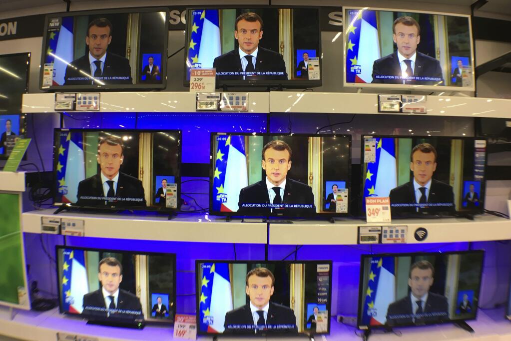 TV screens show French President Emmanuel during a televised address to the nation, at an electrical appliance store in Marseille, southern France, Monday, Dec. 10, 2018. President Emmanuel Macron has acknowledged he's partially responsible for the anger that has fueled weeks of protests in France, an unusual admission for the leader elected last year. (AP Photo/Claude Paris)
