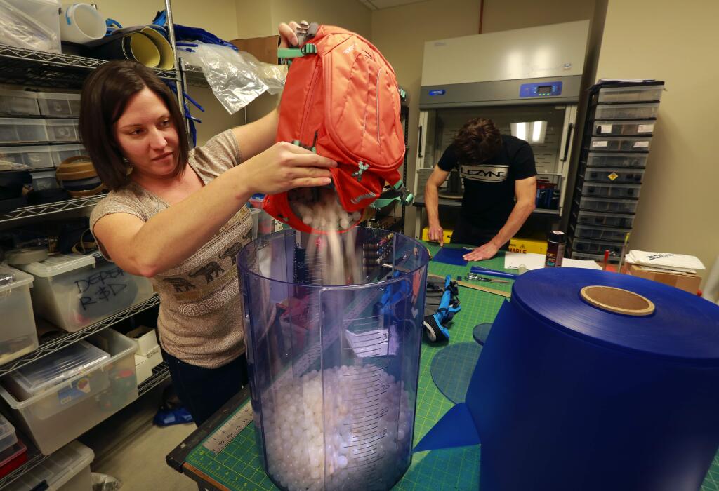 Product developer Aubrey Kraft uses plastic balls to measure the capacity of a pack at the offices of CamelBak in Petaluma. (JOHN BURGESS/ PD FILE)