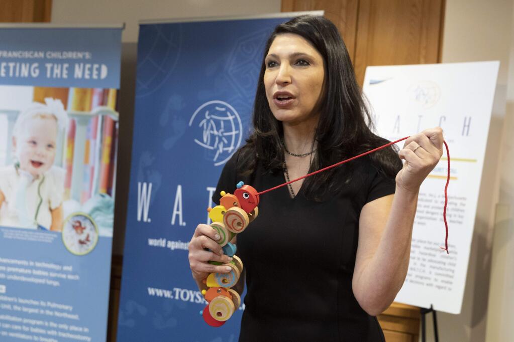 Joan Siff, president of World Against Toys Causing Harm, talks about the danger from strangulation of a pull-along caterpillar toy for infants during a news conference unveiling the organization's list of worst toys for the holidays, Tuesday, Nov. 19, 2019, in Boston. (AP Photo/Michael Dwyer)